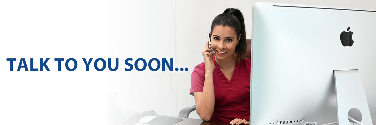 Woman on phone in front of a mac computer